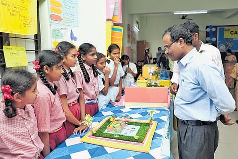 A member of the NXplorers Carnival inspects a model developed by a team of students from an MJP school for girls. Over 146 students took part in the event.