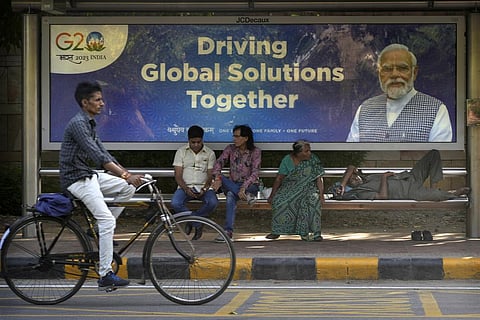 A cyclist rides past a bus waiting shelter with a poster of PM Narendra Modi ahead of this week's summit of the Group of 20 nations in New Delhi, India, Monday, Sept. 4, 2023. (Photo | AP)