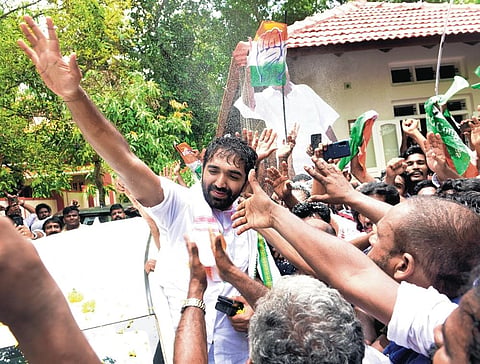 Chandy Oommen waving at supporters in front of Karottu Vallakkalil house at Puthuppally after the bypoll victory
