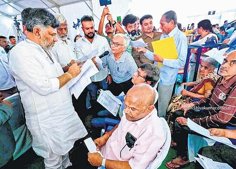 Deputy Chief Minister DK Shivakumar receives petitions from residents during the  ‘Government at Your Doorstep’ programme at Yelachenahalli on Thursday | Express