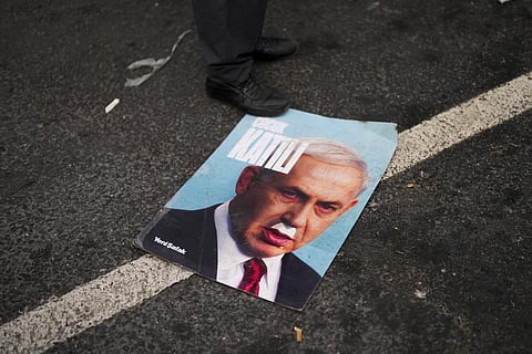 A man stands over a photograph of Israeli PM Benjamin Netanyahu that reads in Turkish: 'Baby killer' during a pro-Palestinain protest in Istanbul, Monday, Jan. 1, 2024. (File Photo | AP)