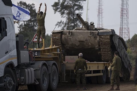 Israeli soldiers load a tank on a transport truck in a staging area at the Israeli-Gaza border in southern Israel, Tuesday, Jan. 2, 2024. (Photo | AP)