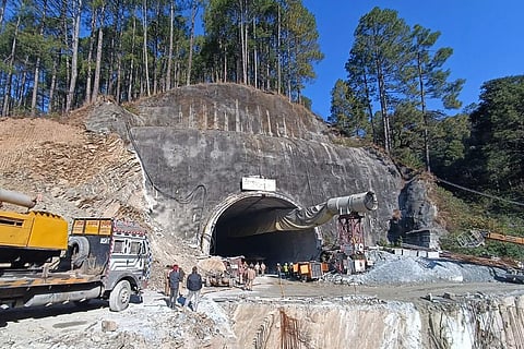 Workers gather near Silkyara tunnel Uttarakhand. (Photo | AFP)