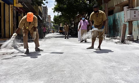 Corporation workers spread disinfectant powder to keep Coronavirus away at Chetti Street in Coimbatore on Tuesday. (Photo | U Rakesh Kumar, EPS) 