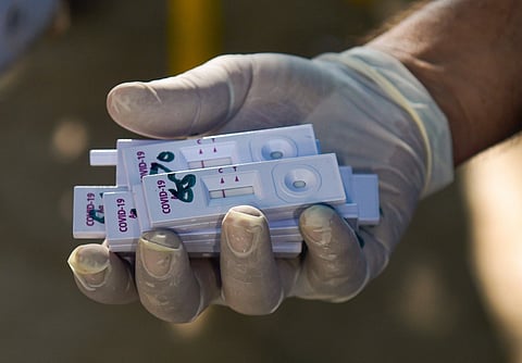 A health worker holds samples collected from construction workers for COVID-19 test. (Photo| PTI)