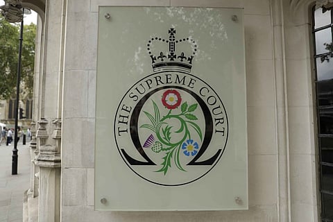 An exterior view shows a sign by the main entrance of the Supreme Court in London, Monday, Sept. 16, 2019. Britain's Supreme Court this week will rule on whether Britain's Prime Minister Boris Johnson overstepped the law when he shut the legislature for a crucial five-week period. Johnson portrays himself as more convinced than ever that Britain will break with the EU at the end of October. (AP Photo/Matt Dunham)