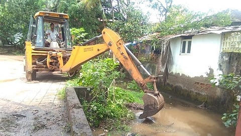 वाडे तळ्यातील पाणी समुद्रात जाणार्‍यां नाल्यातील गाळ जेसीबीद्वारे काढताना.