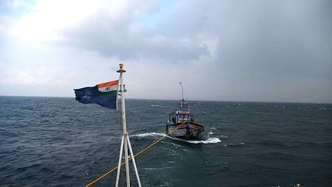 भारतीय तटरक्षक दलाचे जहाज मासेमारी नौकेला   बचाव केल्यानंतर बंदरात आणताना. 