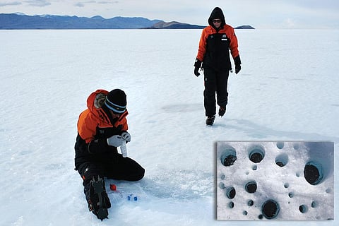 Scientists collecting samples of ice-covered cryoconite holes in Antarctica  (inset) a close-up of the dust holes (Courtesy: NERC)