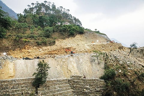 पहाड़ को थामने के लिए बनाई गई कंक्रीट की दीवार यहां कामयाब नहीं है। कीचड़ और छोटे बड़े पत्थर के टुकड़े अक्सर सड़क पर गिर जाते हैं  (फोटोग्राफर विकास चौधरी)