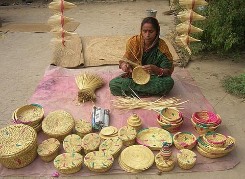 A woman making baskets from golden grass. Credit: Ashish Senapati