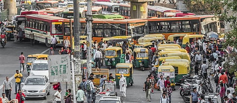 Pedestrians and vehicles on a road in Delhi. Photo: Getty Images