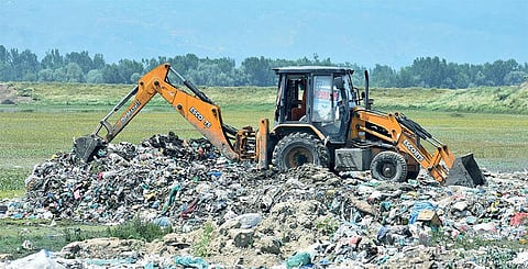 After Jammu and Kashmir High Court’s intervention on July 15,  Sopore Municipal Committee employed 150 workers and JCBs to earth fill the illegal dumpsite they had created along the Wullar lake during the lockdown (Photograph: Hakim Junaid)