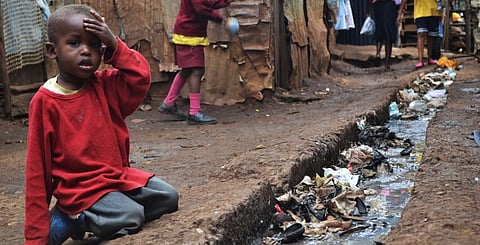 A child sits beside an open sewer in Nairobi's Kibera slum. Photo: Wikimedia Commons