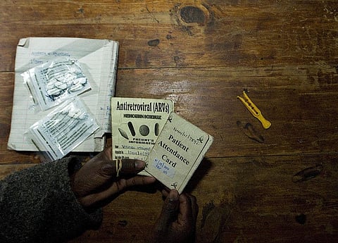 A person living with HIV shows her clinic appointment and anti-retroviral drugs regimen card. Photo: Tony Karumba / AFP / GettyImages