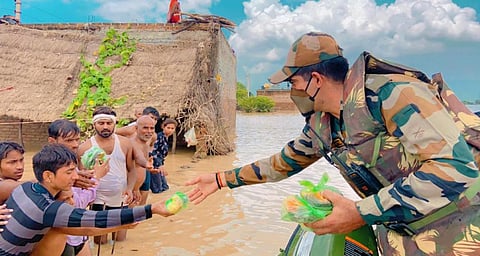 उत्तर प्रदेश के जालौन में  बाढ़ पीड़ितों को राहत सामग्री देते सेना के जवान। फोटो: twitter/@NorthernComd_IA