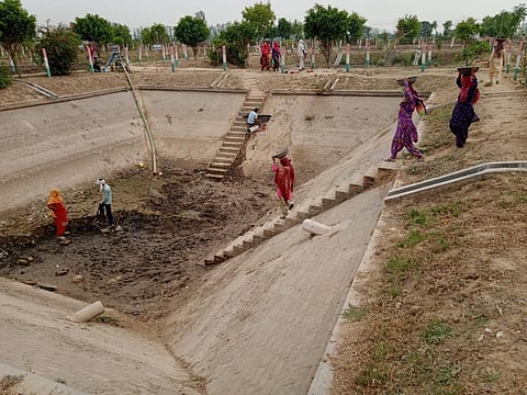 Workers clean an anaerobic pond in Kurak Jagir village in Haryana’s Karnal district. Photo: Ravi Kumar 