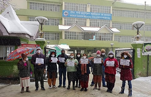 हिमाचल प्रदेश के एनएचएम कर्मचारियों ने प्रदेश के सबसे बड़े अस्पताल में काम बंद रखा और भारी बर्फबारी के बीच में प्रदर्शन किया। फोटो: रोहित पराशर