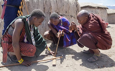 Maasai warriors trying to light a fire in Tanzania. Photo: iStock