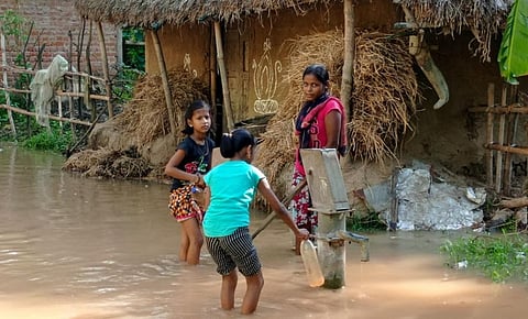 Flood-hit villagers collecting water from a submerged tubewell in Kendrapara district. Photo: Ashis Senapati