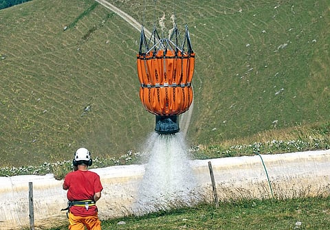 A Swiss Air Force helicopter drops water for cows in Tissiniva mountain pasture due to an ongoing drought in Charmey, Switzerland on August 10  (Photograph: Reuters)