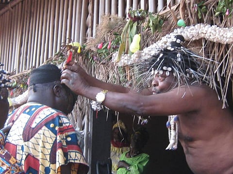 His Royal Highness, Fon Tarh Kilengse conferring a local resident with a red feather of Bannerman’s Turaco for his service to the community. Photo: Samson Websi