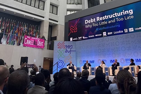 CodePink activists Olivia DiNucci and Nancy Mancias disrupted the panel with a banner asking the institutions to “cancel all debts.” Photo: CodePink