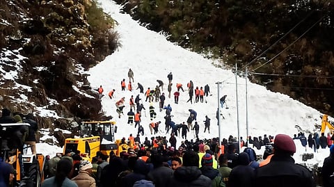 Rescue personnel dig in the snow at the avalanche site in the hunt for survivors. Photo: Dichen Ongmu