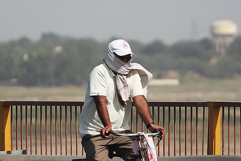 प्रयागराज में गंगा किनारे भीषण गर्मी और लू के थपेड़ों के बीच जाता एक साइकिल सवार; फोटो: आईस्टॉक