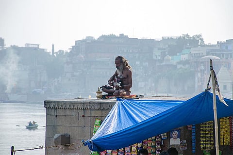 वाराणसी के एक घाट पर वाद्य यन्त्र बजाते नागा साधु; फोटो: आईस्टॉक