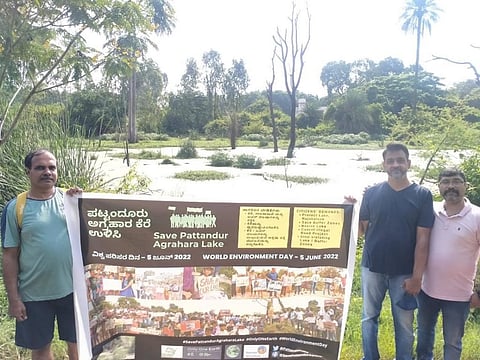 Activists hold a placard on World Environment Day at the Pattandur Agrahara Lake in  Bengaluru East. Photo arranged by Covorcolly Indresh