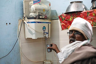 Jhajjar resident 68-year-old Hira Singh taking water from an RO system in his home. Photo: Vikas Choudhary / CSE