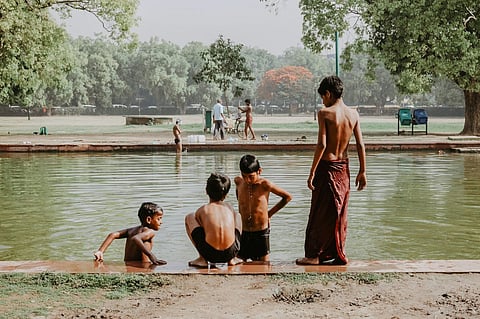 Kids splash in a pond on a hot day