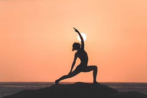 Silhouette of a woman doing yoga during sunset