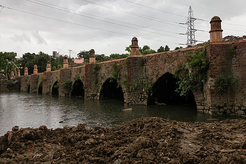 The Barapullah bridge, a 400-year-old Mughal-era structure, lies hidden beneath the modern Barapullah flyover in Delhi, largely forgotten by the city’s residents.
