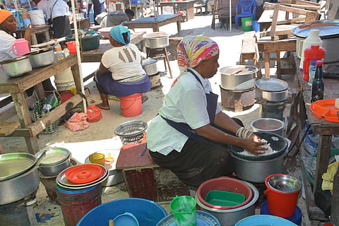 Hadija Salum cooking at Temeke Stereo Market to support her family.  Salum has been struggling to acquire a land title since her husband died in 2016.