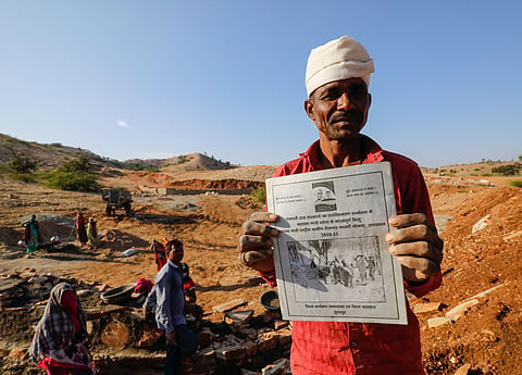 A man working under the Mahatma Gandhi National Rural Employment Guarantee Scheme displays his job card in Rajasthan’s Dungarpur district.