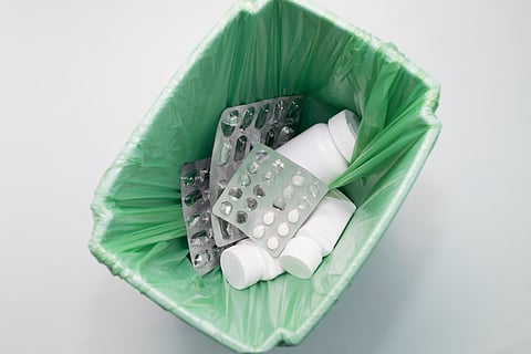 Top View: Medication, Supplement, Pills, Tablet Bottles, and Empty Capsule Pastilles in Trash Bin