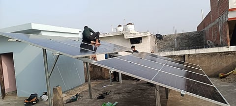 Workers installing solar panels at a house in Prayagraj. 