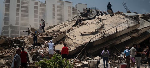 People search through the rubble of collapsed buildings in La Guaira, Venezuela.
