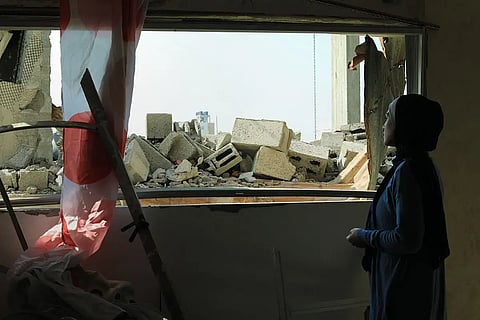 A woman, Nour, stands amid the rubble of her home in Beit Lahia, North Gaza, after being displaced by the war. Nour’s husband, a nurse, was detained during the war and she hasn’t seen nor heard of him since. February 2025. 