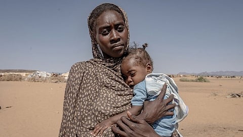 A woman displaced by fighting in El Fasher holds her six-month-old daughter, who was recently treated for malnutrition, in Tawila, where they sought refuge.
