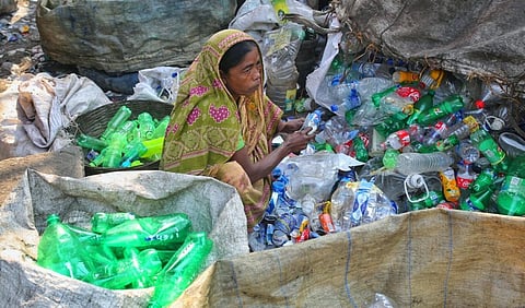 A labourer sifts through plastic waste for recycling in Dhaka, Bangladesh. Photo: iStock