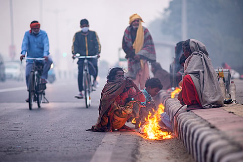 दिल्ली की बढ़ती सर्दी में आग की मदद से अपने आप को गर्म रखने का प्रयास करते लोग; फोटो: आईस्टॉक 