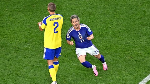 Japan's Daizen Maeda, right, celebrates after scoring their opening goal during the World Cup Group F soccer match between Japan and Sweden in Arlington