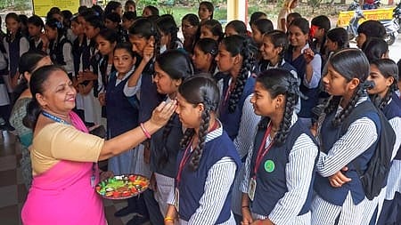 Indore: A teacher applies tilak to students on their foreheads as schools reopen after summer vacation in Madhya Pradesh, Indore on Monday, June 16, 2025. 