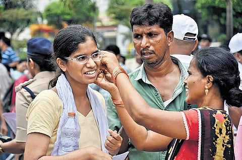 A woman removes her daughter’s ear rings before she enters the examination centre to attend the NEET in Vijayawada on Sunday 