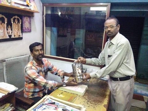 Volunteer of Nesakaram Dabbawala delivering home-cooked food to a customer (Pic: Nesakaram)