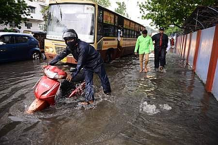 A man pushes his scooter on a flooded road near Egmore after heavy rainfall ahead of cylone Nivar landfall in Chennai | Pic: EPS