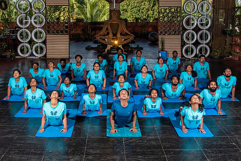 Yoga pupils practising along with the trainer